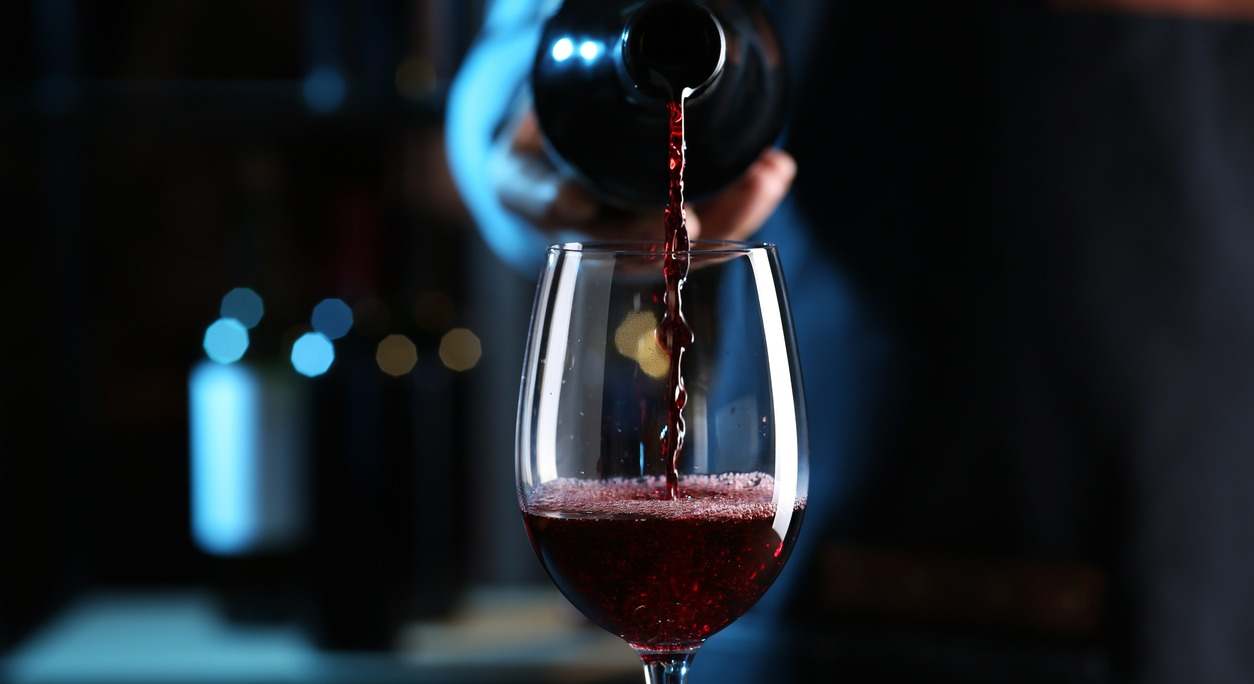botella de vino sirviendo en una copa