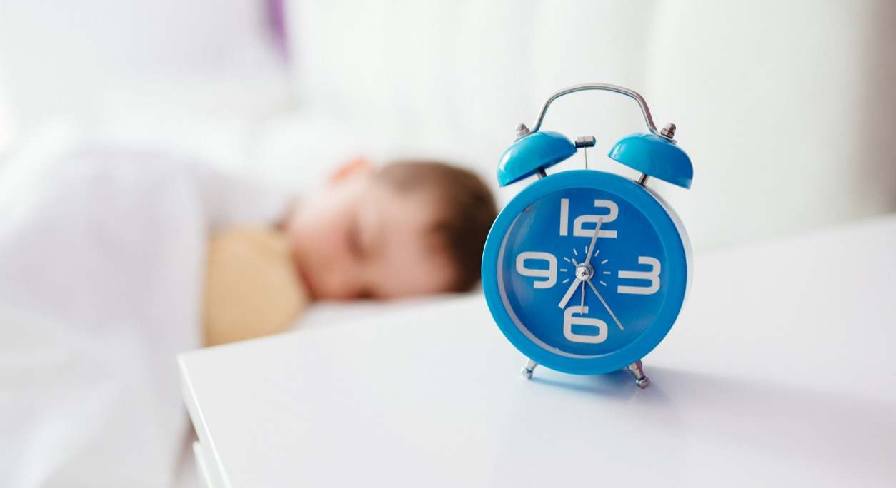 niño durmiendo cama despertador
