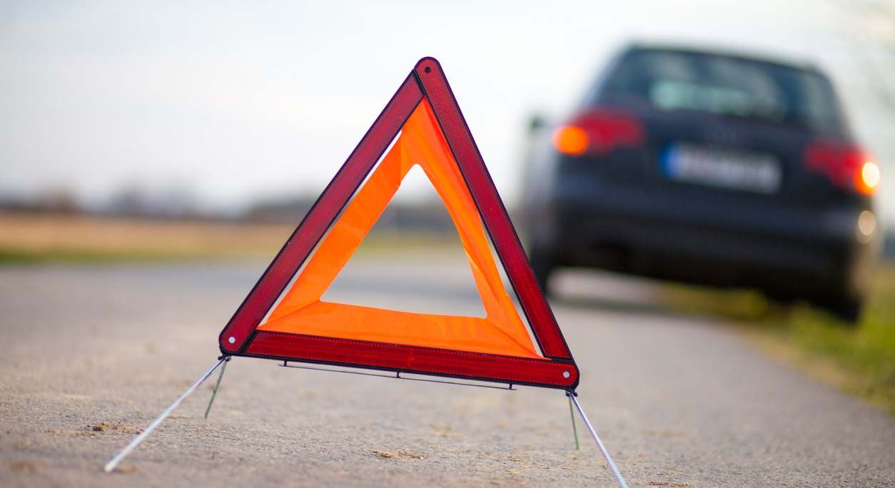 Un conductor coloca un triángulo en la carretera