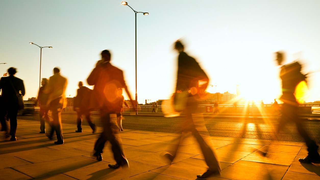 Gente andando por la calle al atardecer en una imagen de iStock