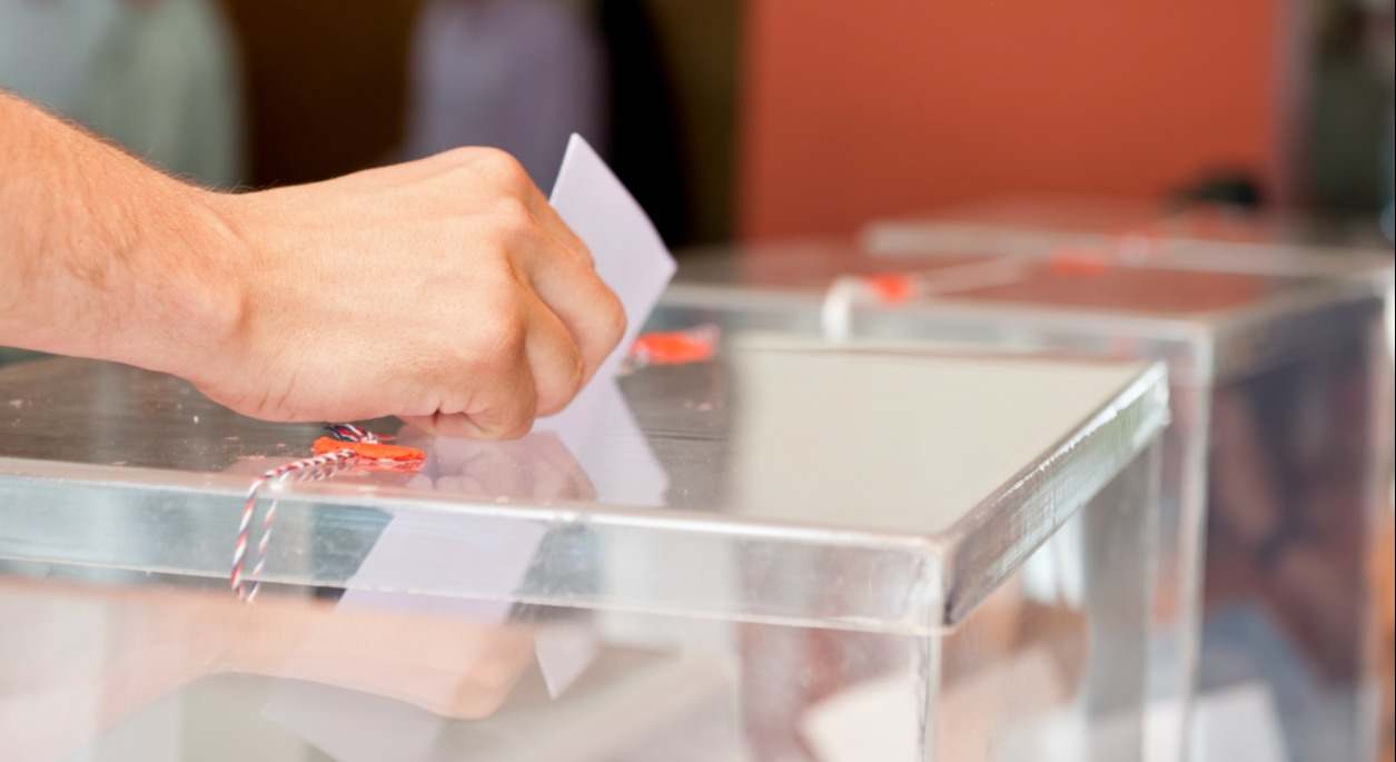 un votante introduce su voto en una urna