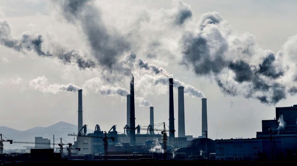 Una fábrica emitiendo gases de efecto invernadero a la atmósfera