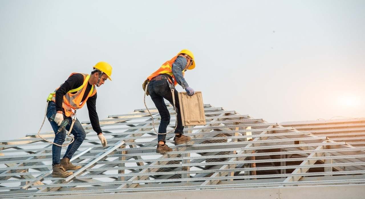 Imagen de recurso de obreros de la construcción trabajando en la estructura del techo de un edificio