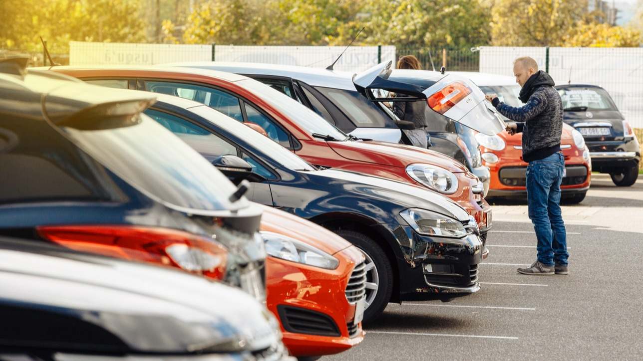 un comprador escoge un coche en un concesionario