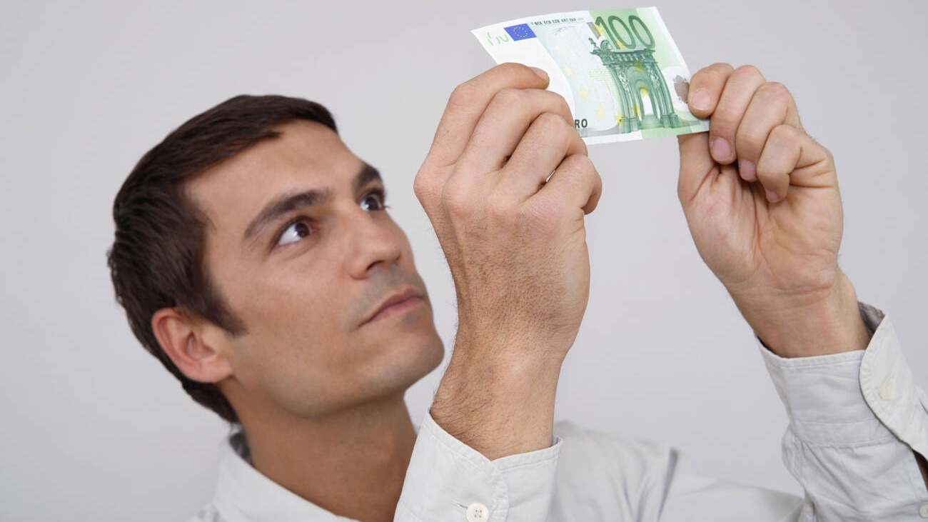 Persona mirando si un billete es falso