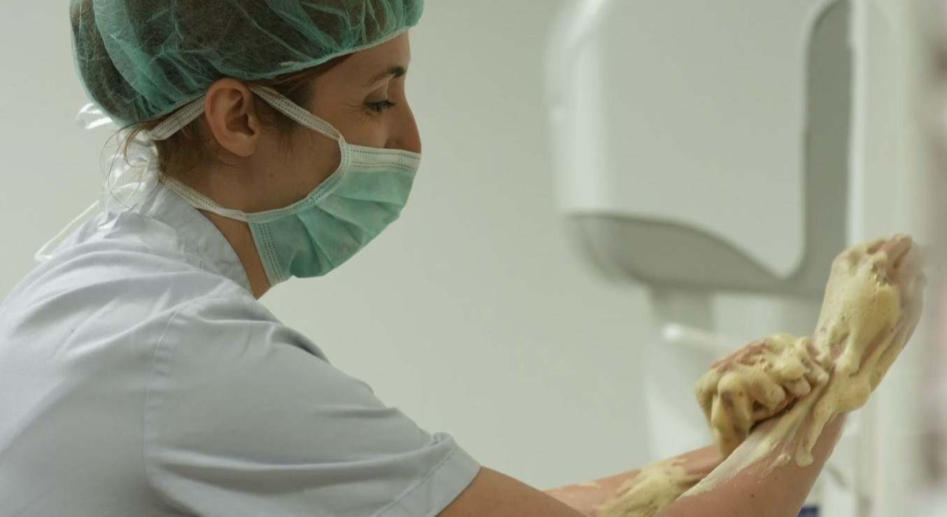 Un profesional sanitario se prepara para entrar en un quirófano. 
