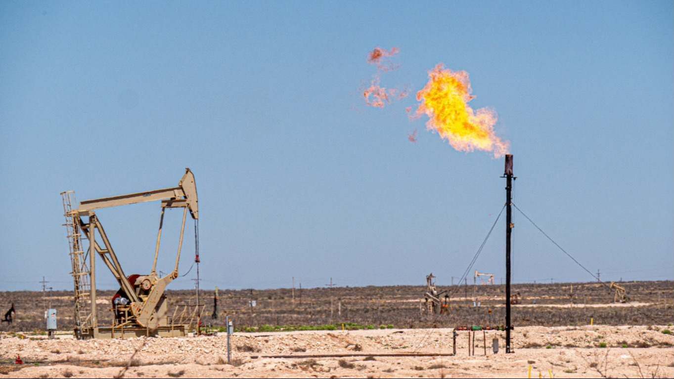 Un pozo de petróleo al lado de una tubería que echa fuego