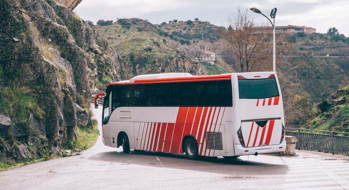 Autobús circulando por una carretera local. / iStock