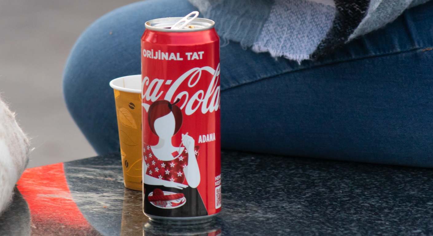 Persona sentada junto a una lata de Coca-Cola