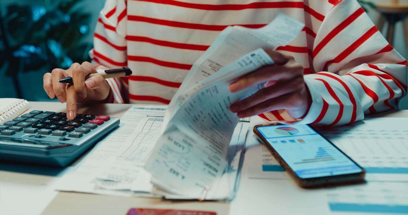 una persona estudia su factura con una calculadora
