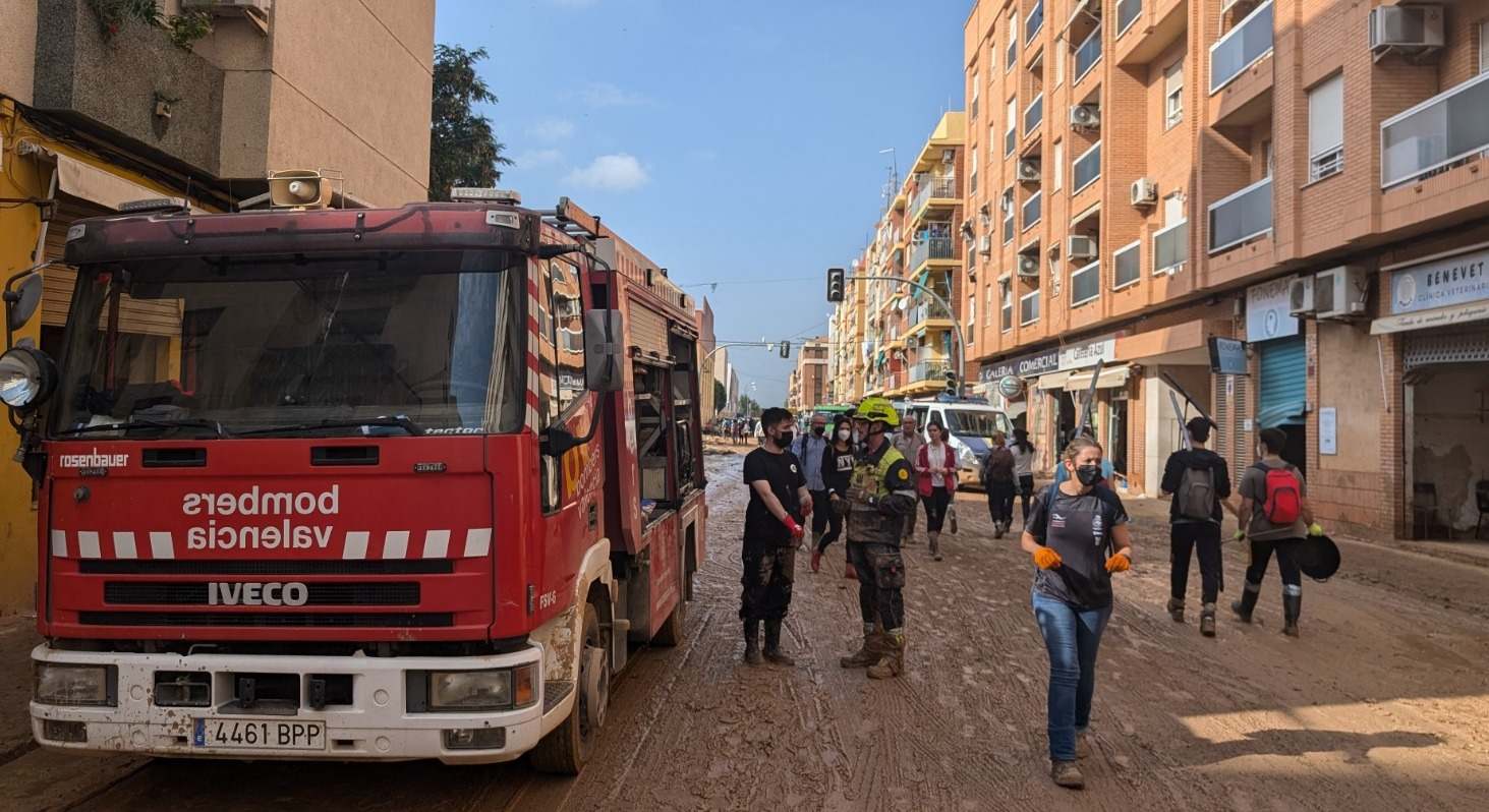 Un equipo de bomberos junto a edificios afectados por la DANA.