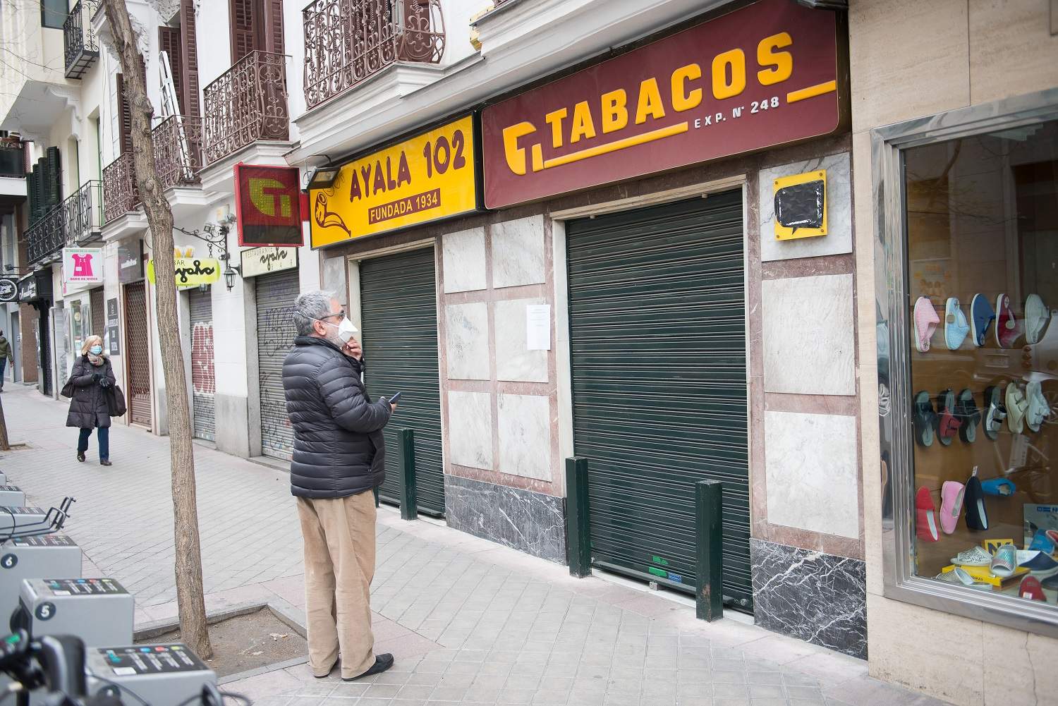 EuropaPress_2721028_mujer_mascarilla_mira_puerta_cerrada_estanco_pesar_servicios_mantiene.jpg