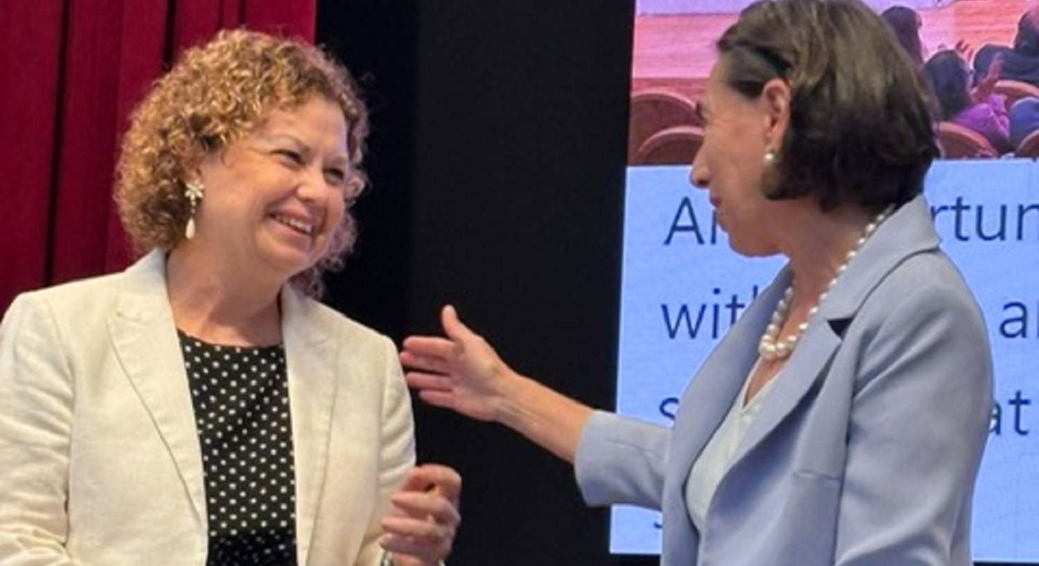 La decana del Colegio de Registradores, María Emilia Adán (i.), recoge el reconocimiento.