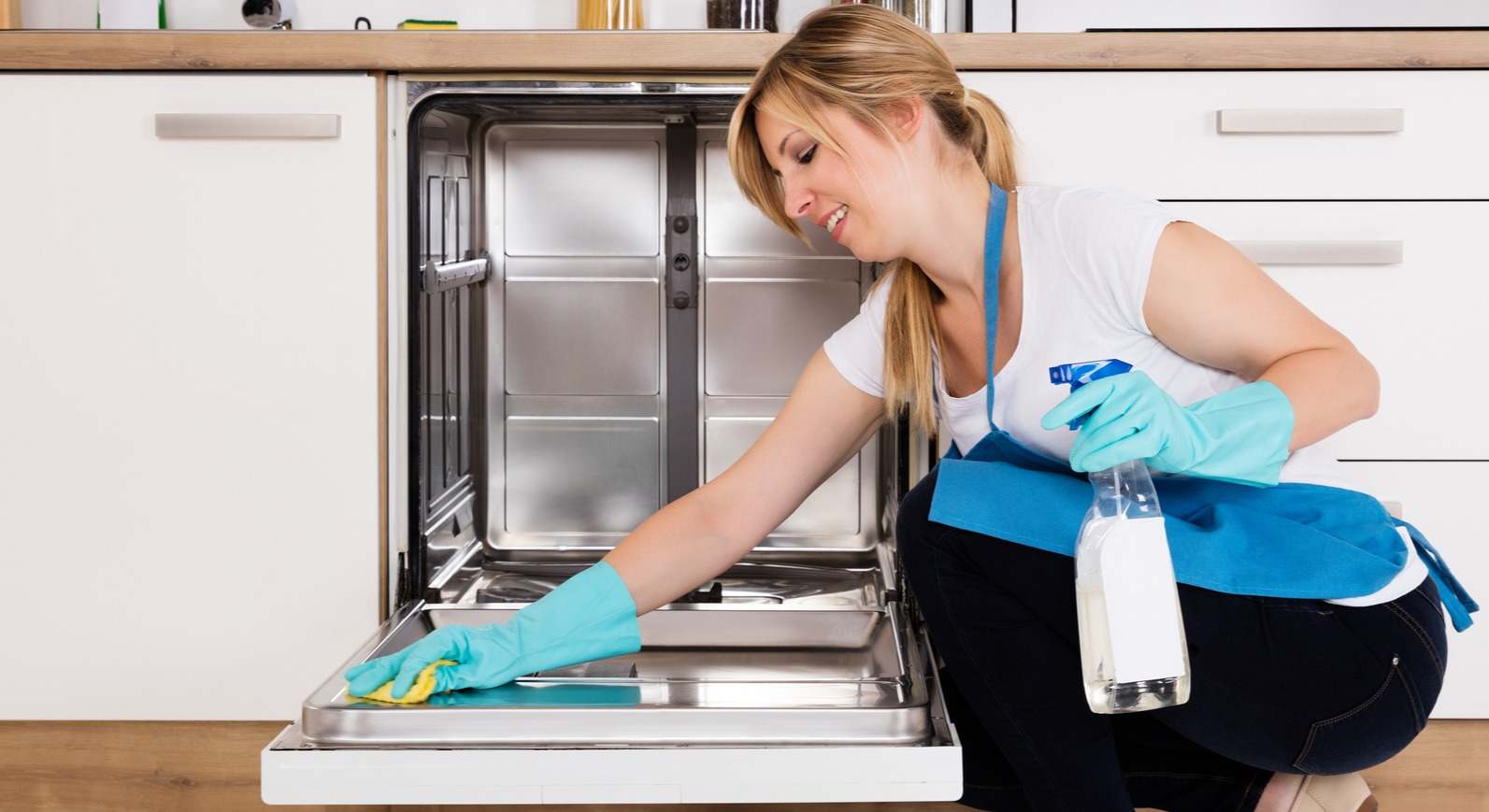 Una mujer limpia el interior del lavavajillas. / Foto: iStock