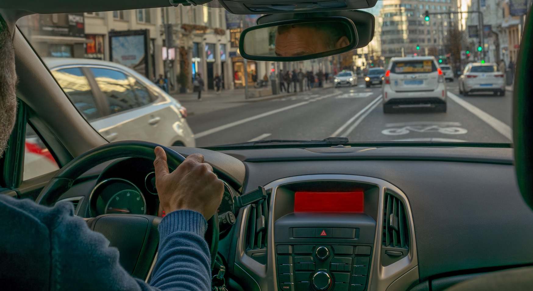 Hombre conduciendo solo en ciudad