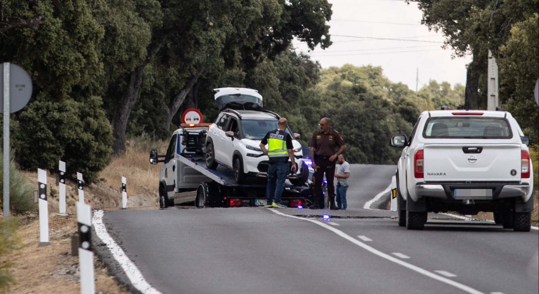 Un grúa recoge el vehículo del suceso de Borja Villacís, en el kilómetro 6 de la M-612, en la carretera de Fuencarral-El Pardo