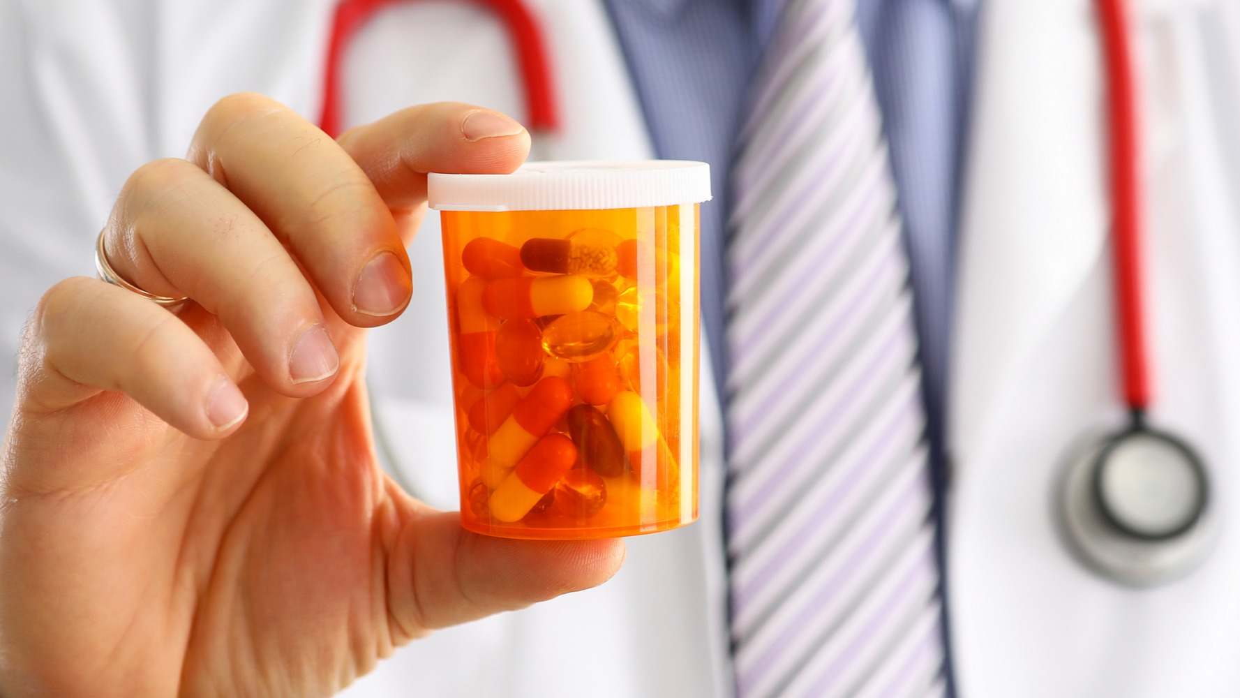 Médico sosteniendo un bote de píldoras