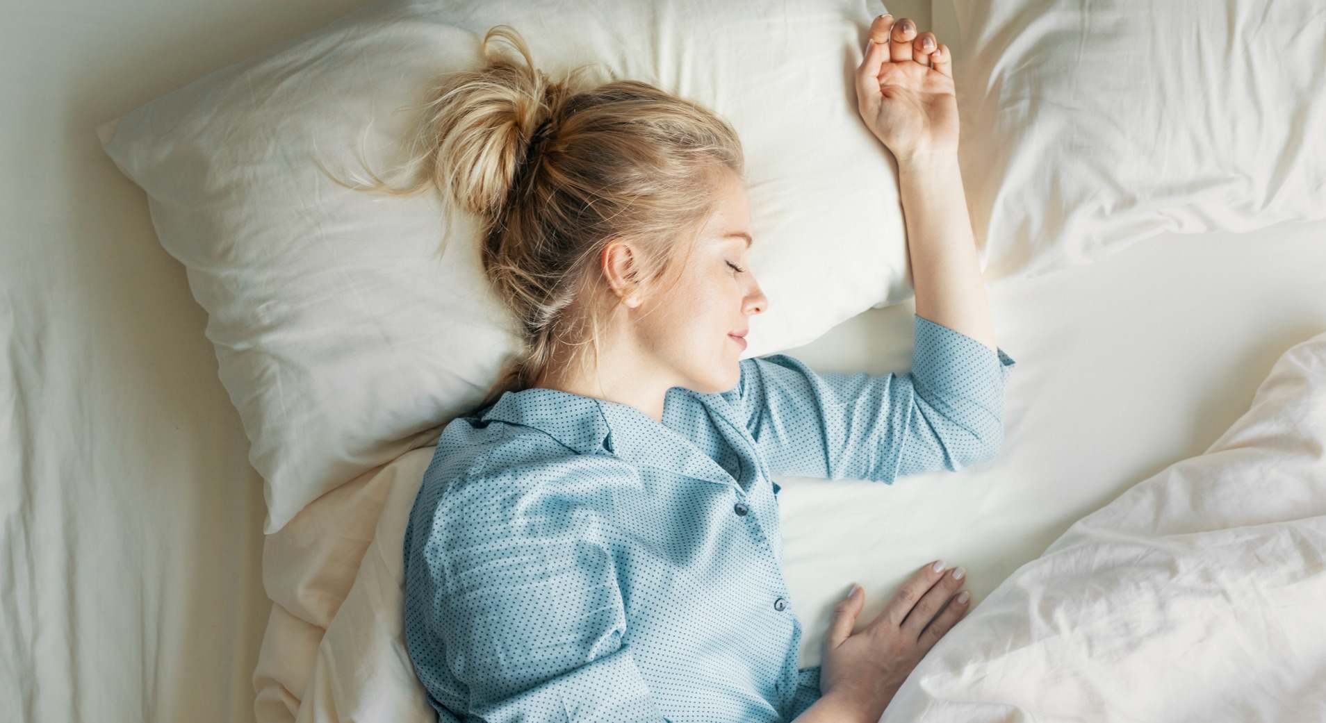 Mujer de pelo rubio durmiendo en la cama