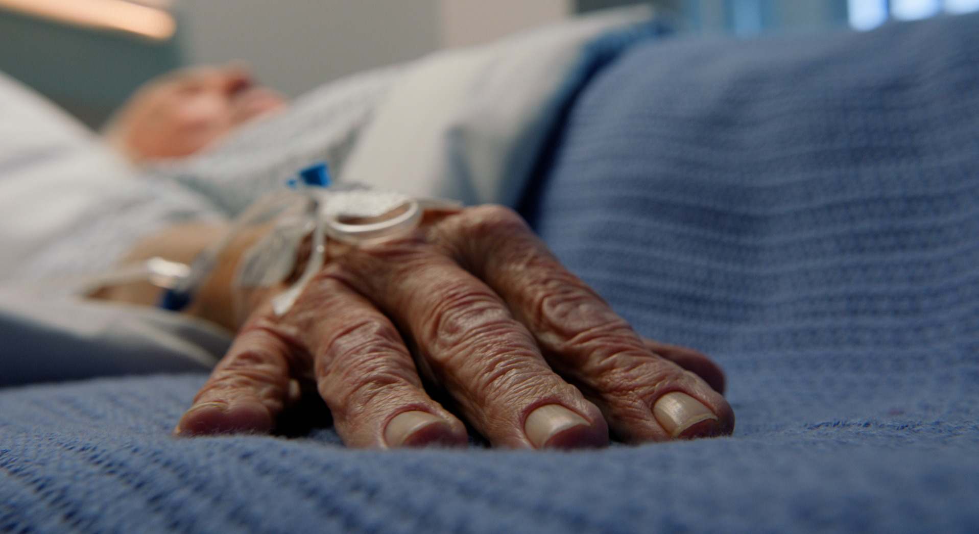 Mano de un hombre en la camilla de un hospital