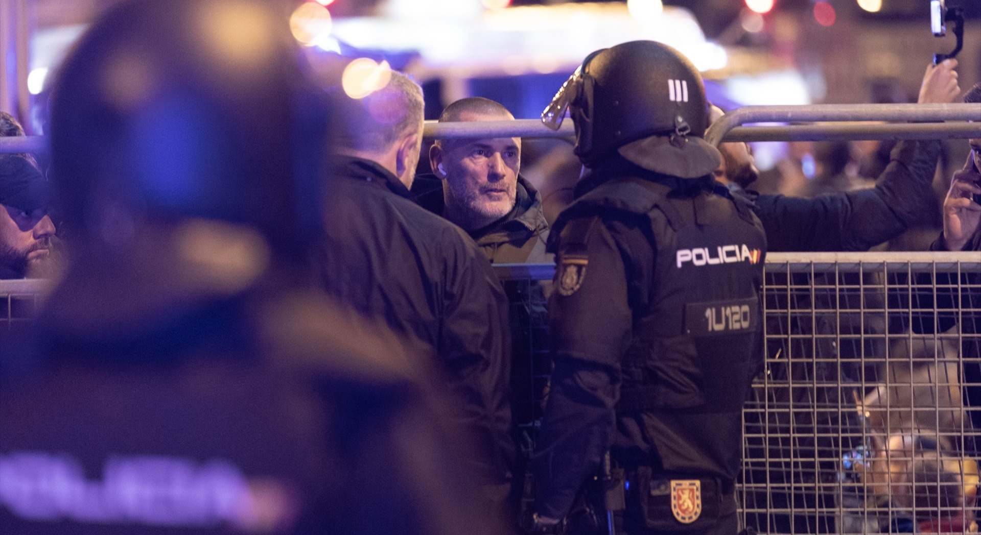 Un policía nacional habla con el líder de Desokupa, Daniel Esteve