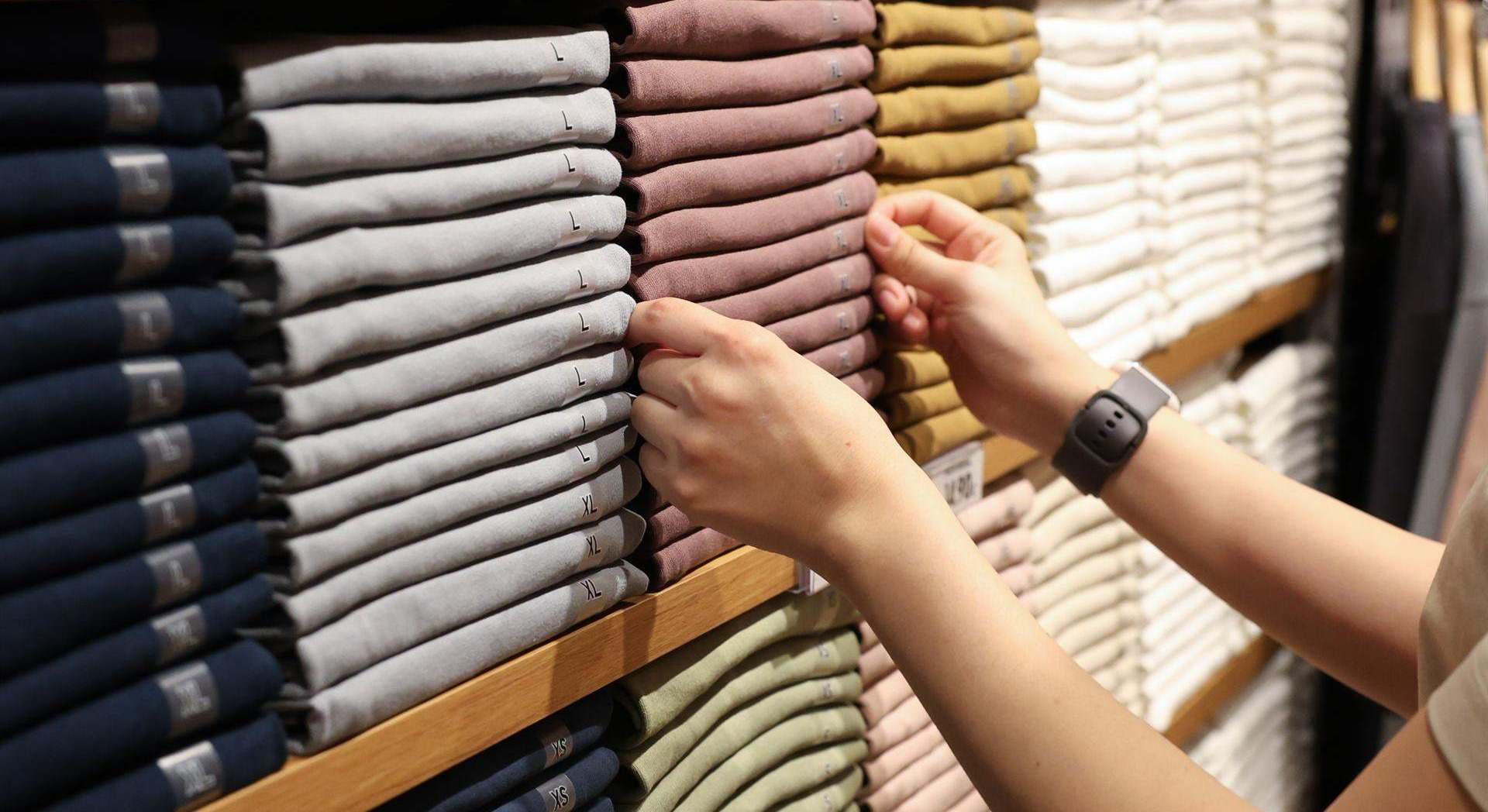 Una dependienta coloca la ropa en una tienda