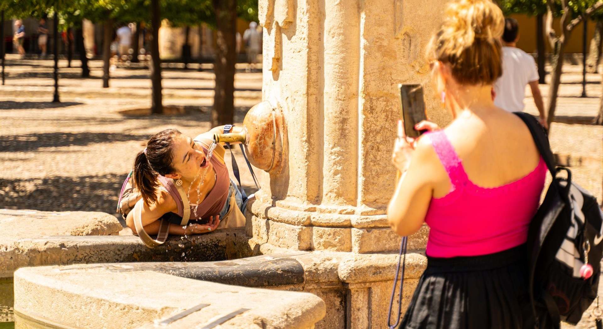 Turistas se refrescan con agua para hacer frente a las altas temperaturas