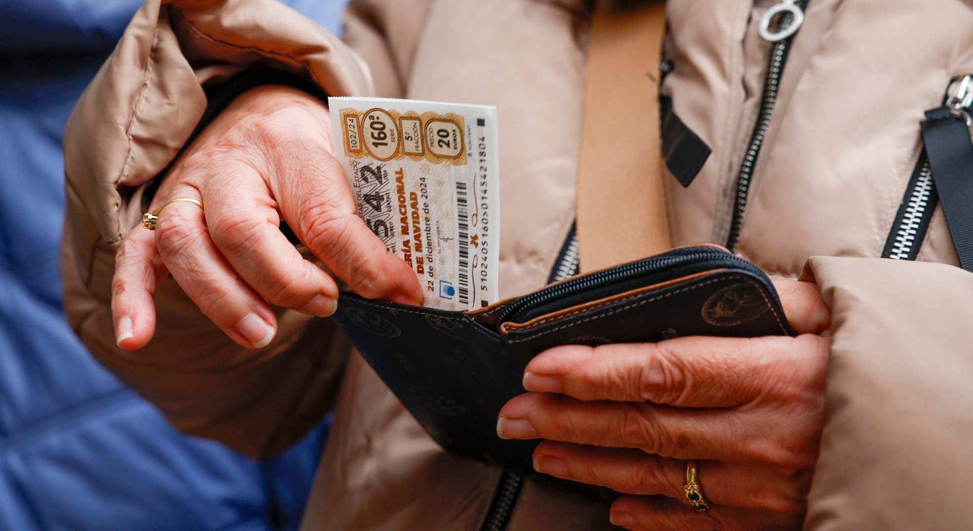 Una mujer guarda un décimo de la Lotería de Navidad. / Foto: EFE