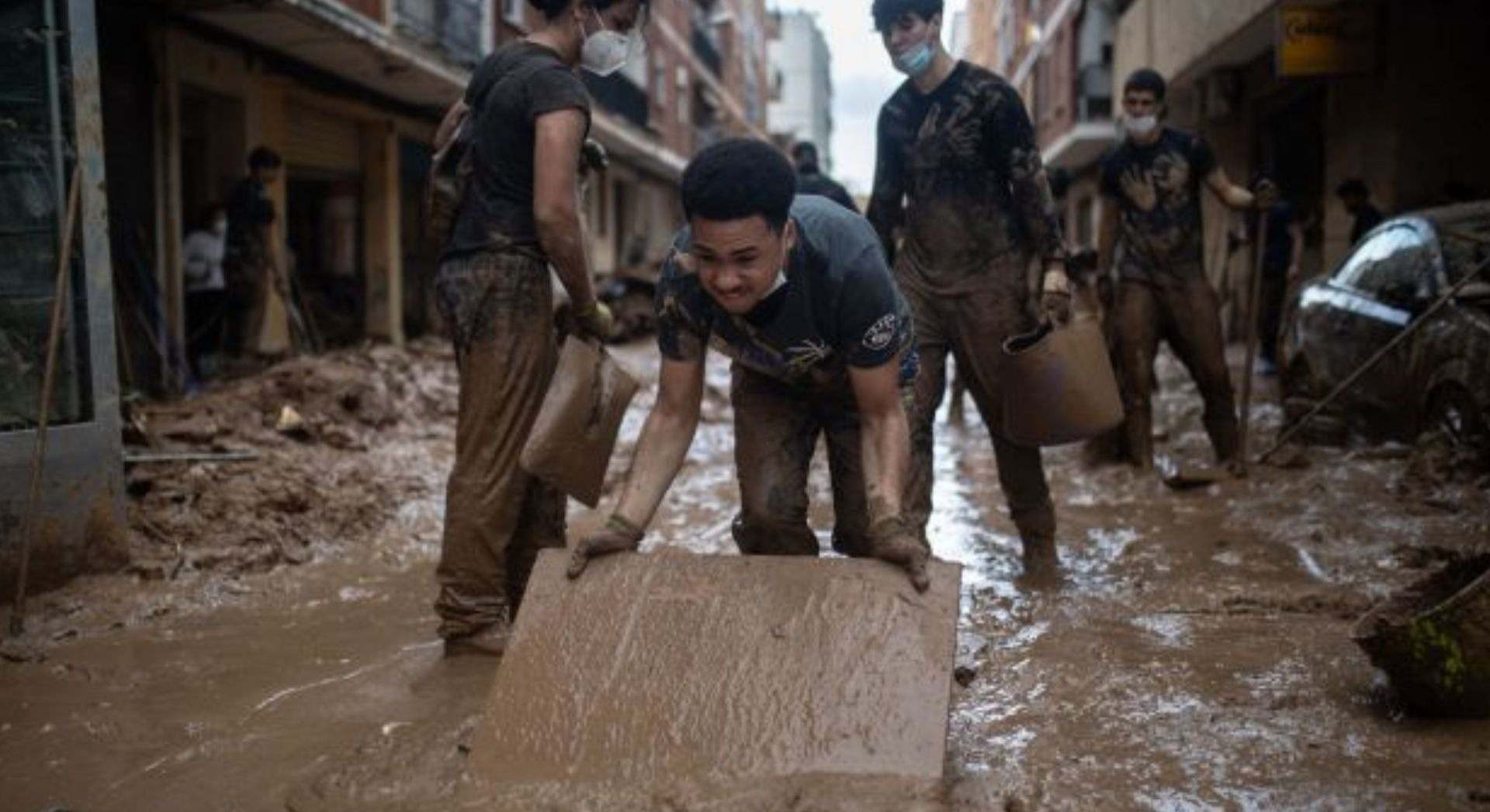 Varios voluntarios ayudando a limpiar el suelo en Paiporta