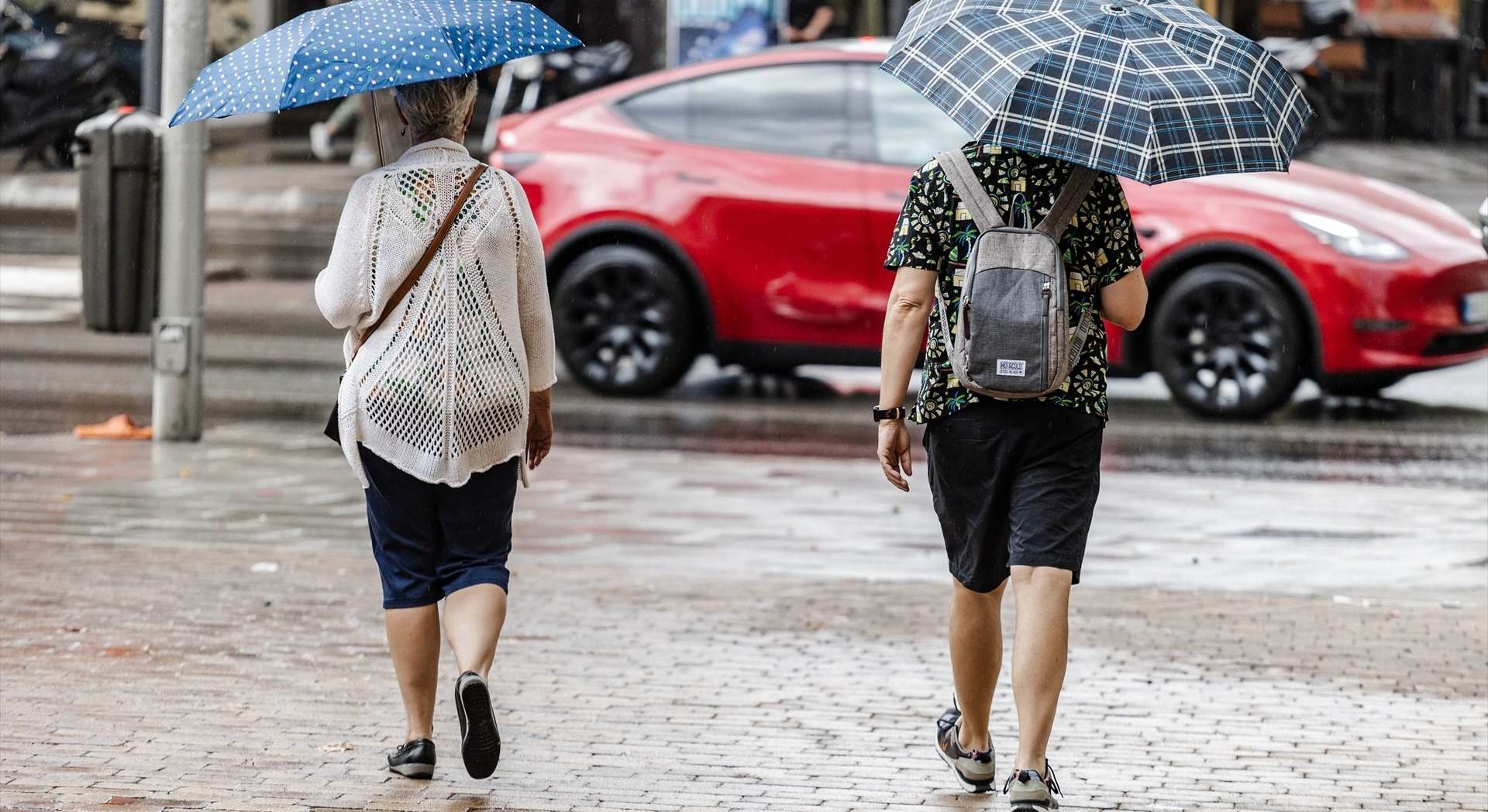 Dos personas caminan bajo la lluvia