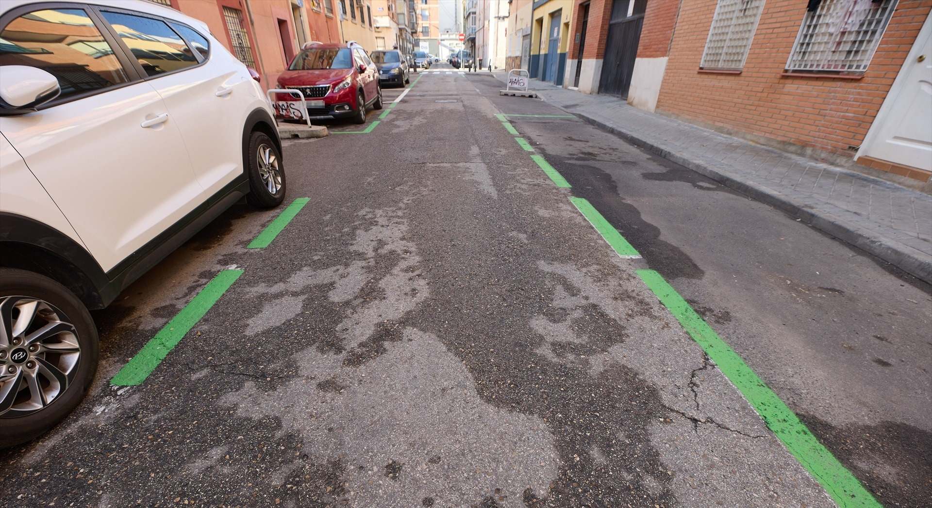 Varios coches aparcados en la zona SER del barrio de Usera