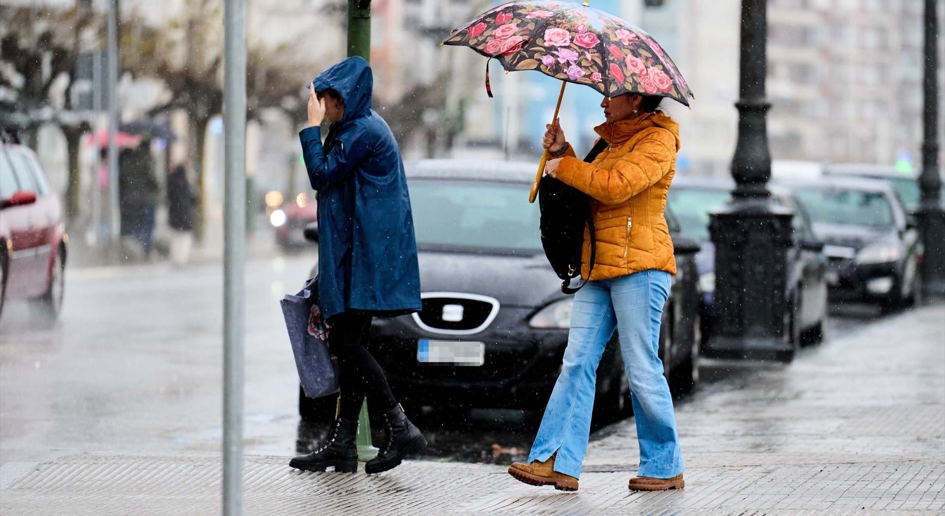 Dos personas se protegen de la lluvia en España