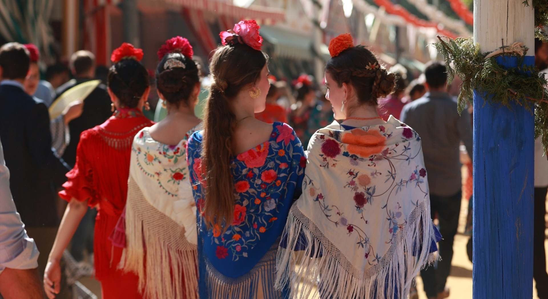 Jóvenes vestidas de sevillana en el ambiente en el Real de la Feria de Sevilla