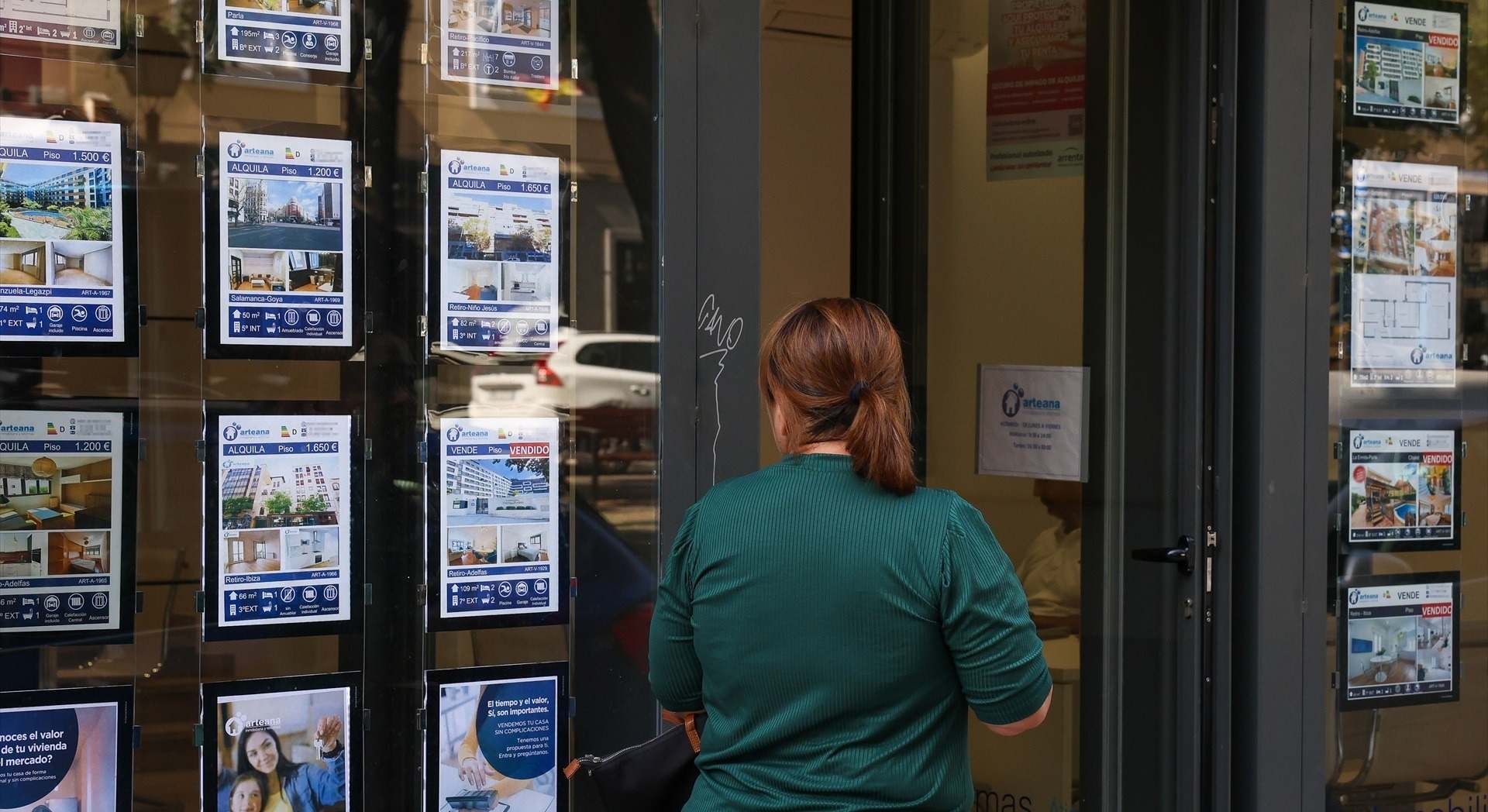 Una mujer mira los anuncios de una inmobiliaria.