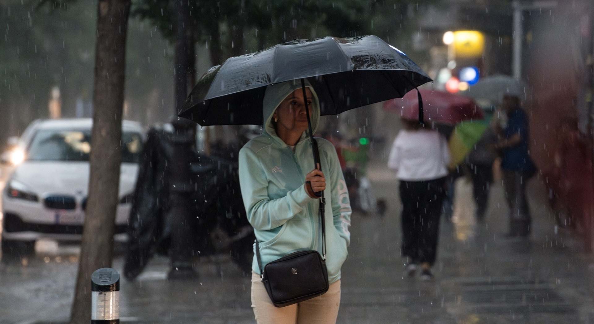 Una mujer con paraguas bajo la lluvia