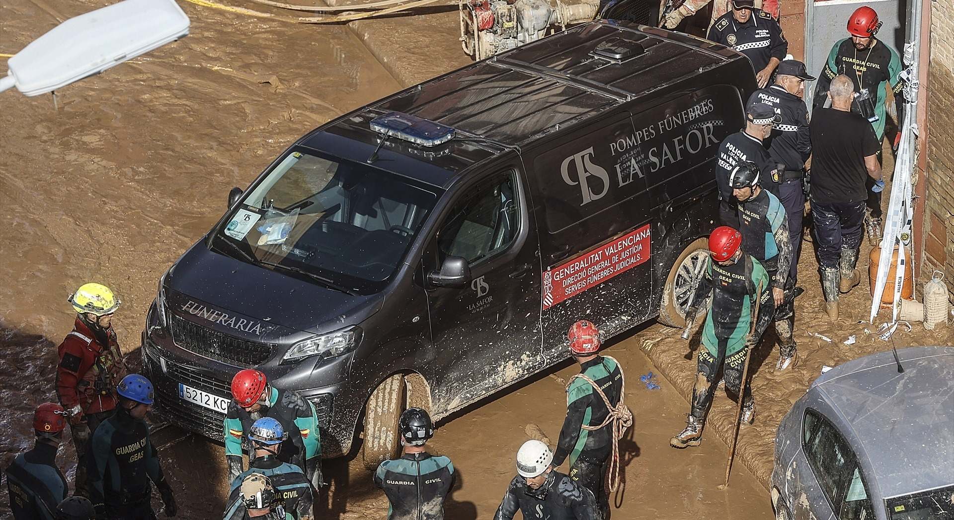 Un furgón de la funeraria sale de un garaje con cadáveres localizados tras el paso de la DANA, en el barrio de la Torre, en Valencia.
