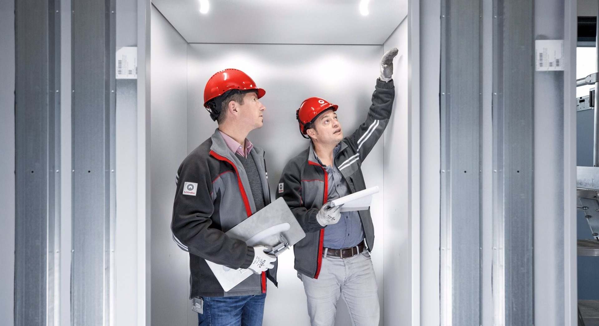 Dos técnicos inspeccionan un ascensor