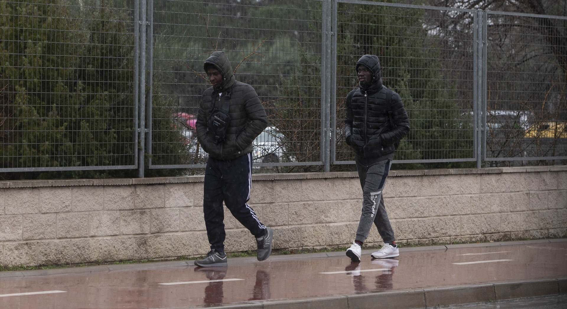 Dos migrantes caminan en las inmediaciones del centro de Emergencia, Acogida y Derivación en el Acuartelamiento 'Primo de Rivera'