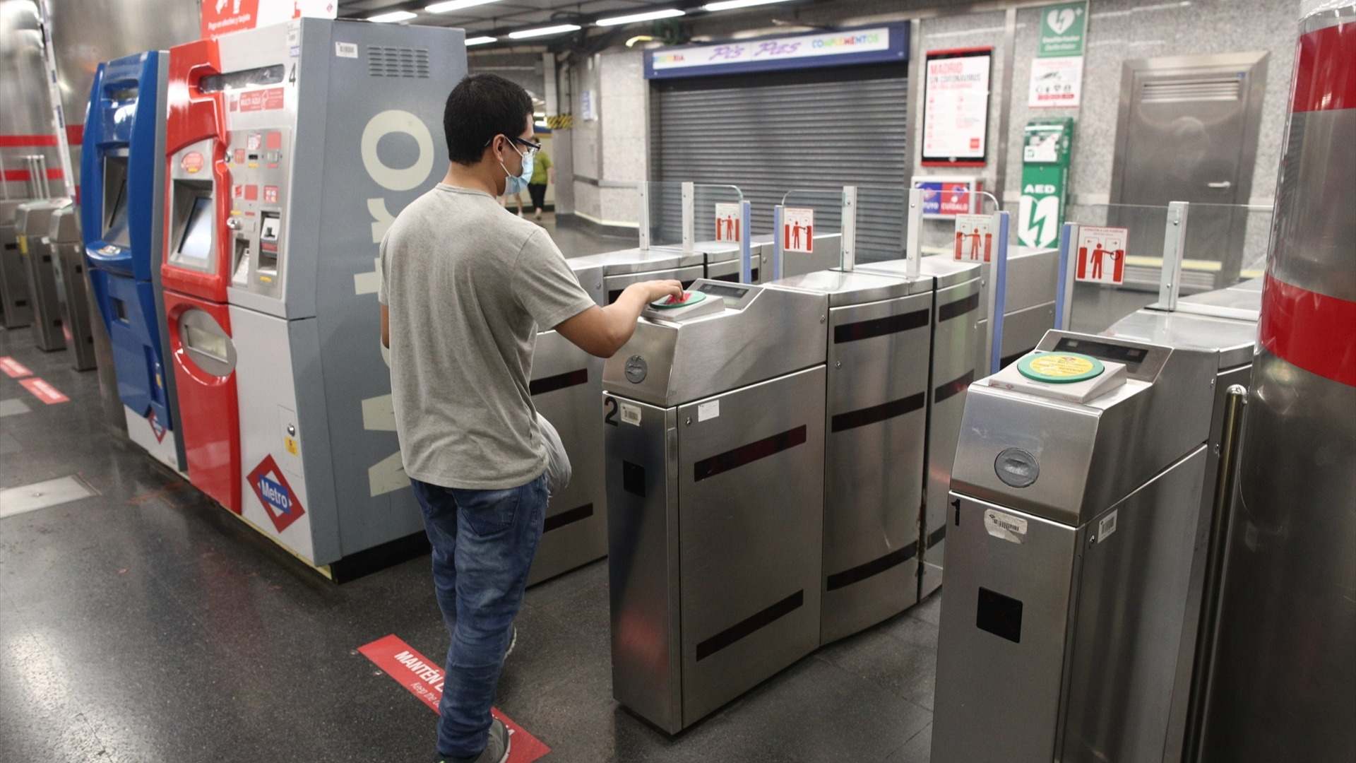 Un joven pasa su billete en el torno del Metro Plaza de España, en Madrid