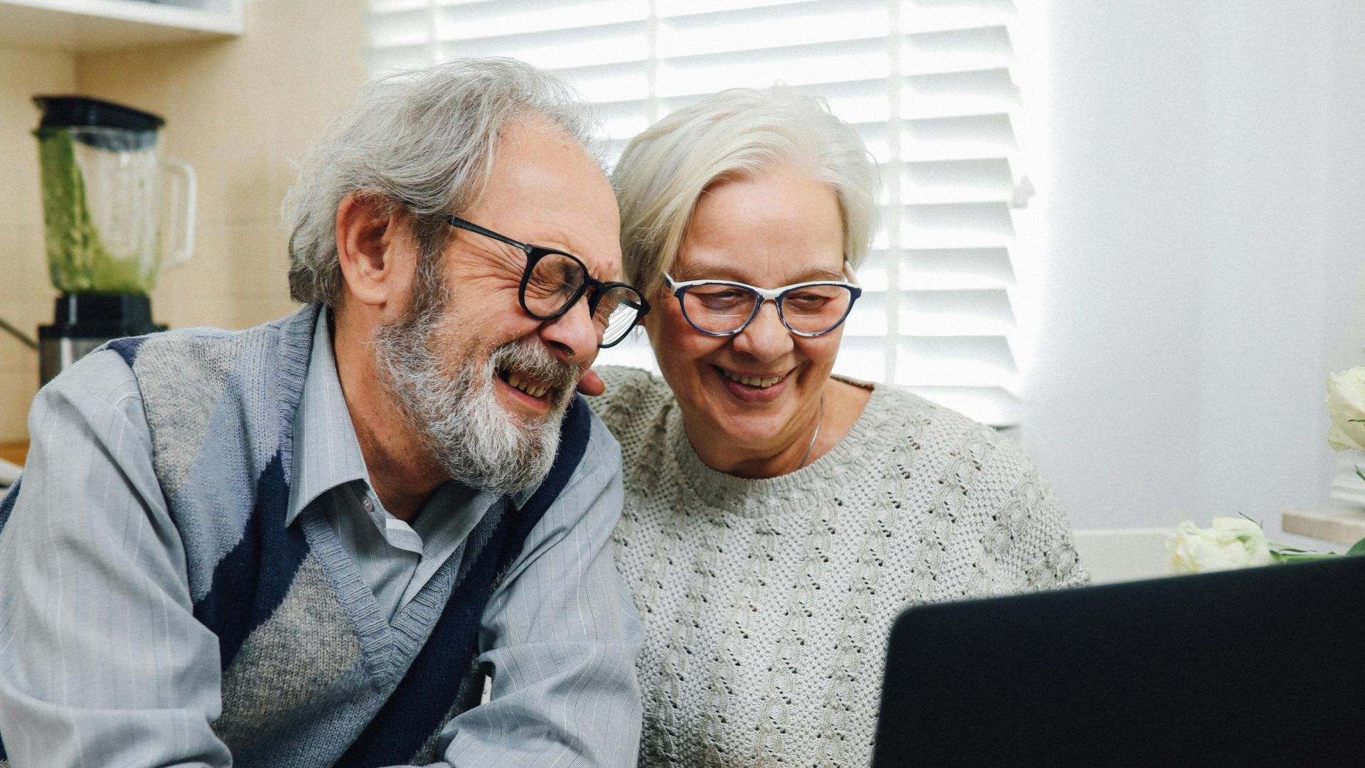 Dos personas de avanzada edad mirando una cosa en el ordenador