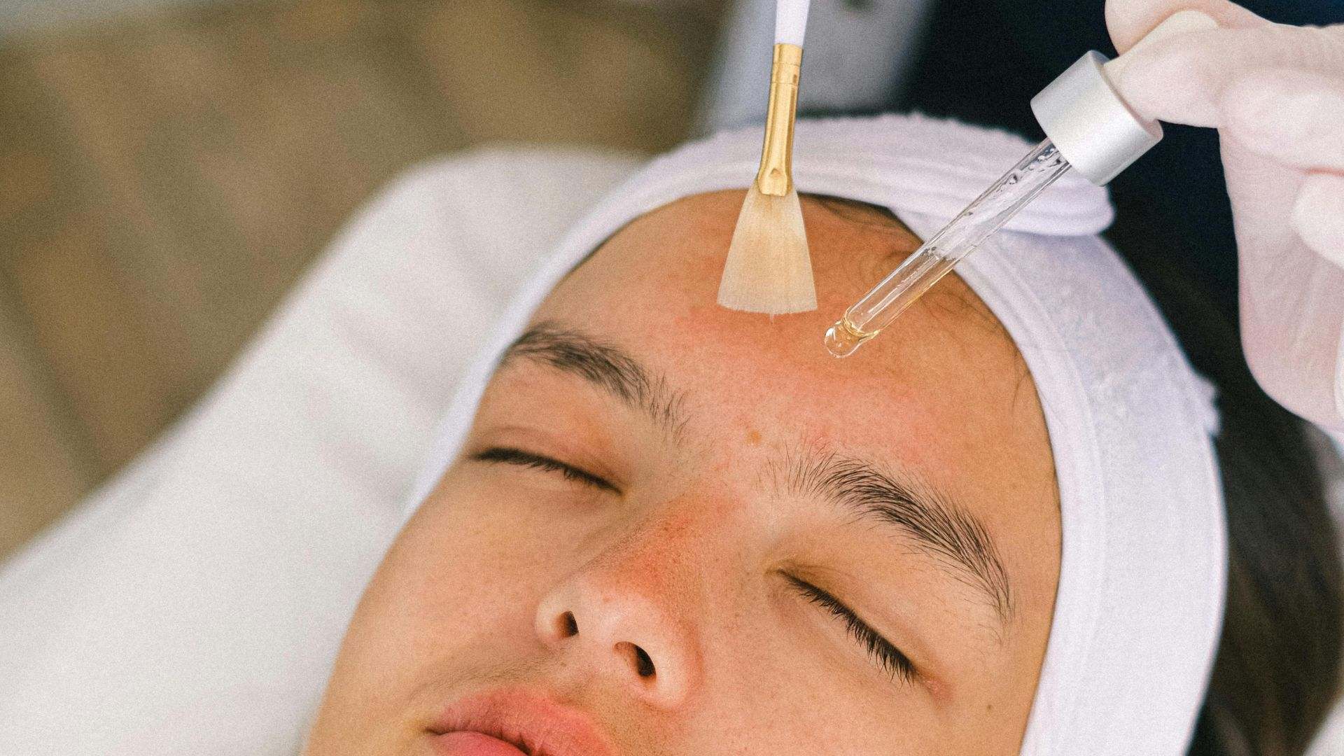 A una mujer le están aplicando un producto cosmético