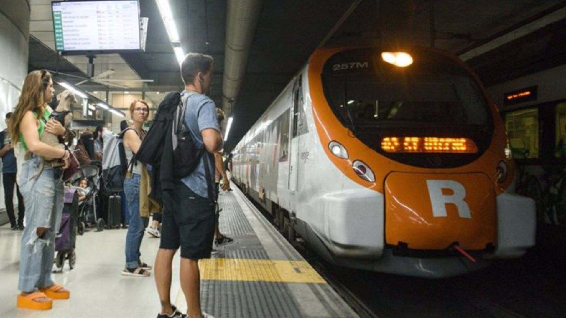Varios pasajeros en el anden de los trenes de Renfe Rodalies