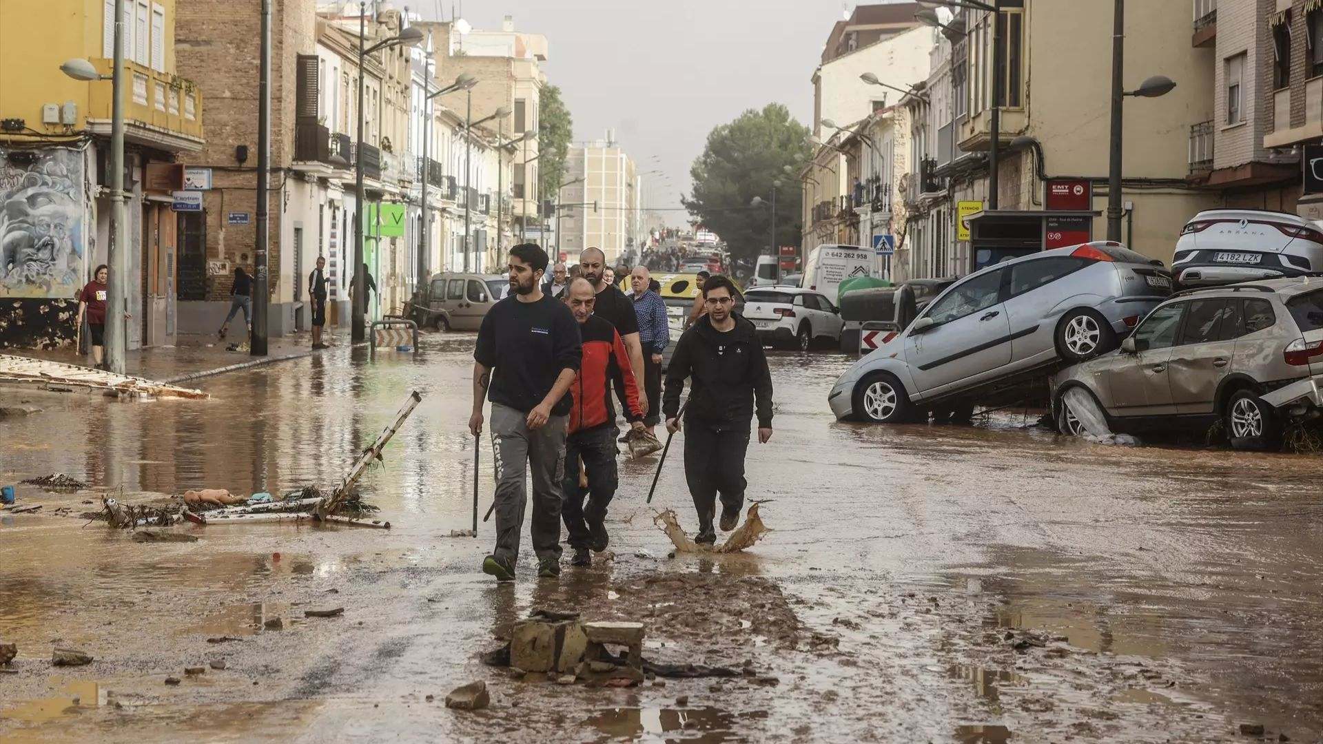 Numerosas personas recorren calles llenas de agua y barro tras el paso de la DANA por el barrio de La Torre de València