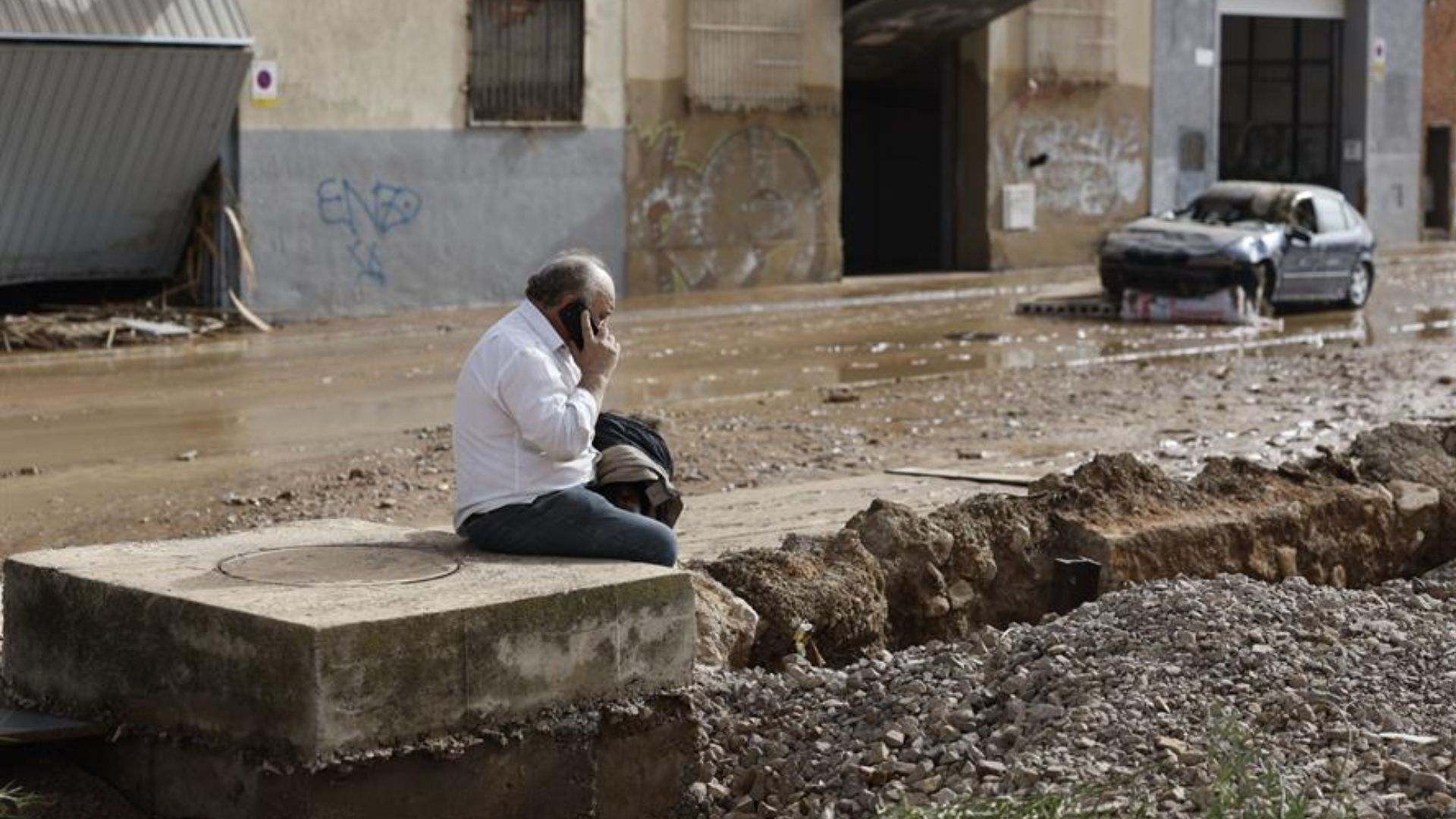 Un individuo habla por teléfono en una de las zonas de Valencia afectadas tras las intensas lluvias por la fuerte dana que afecta especialmente el sur y el este de la península ibérica, este miércoles en Valencia