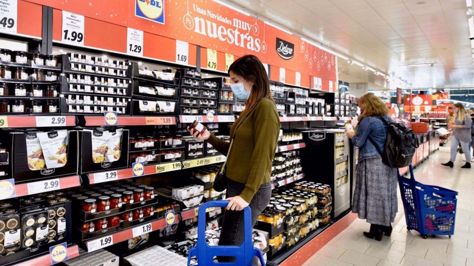Una mujer observa un producto de un supermercado español