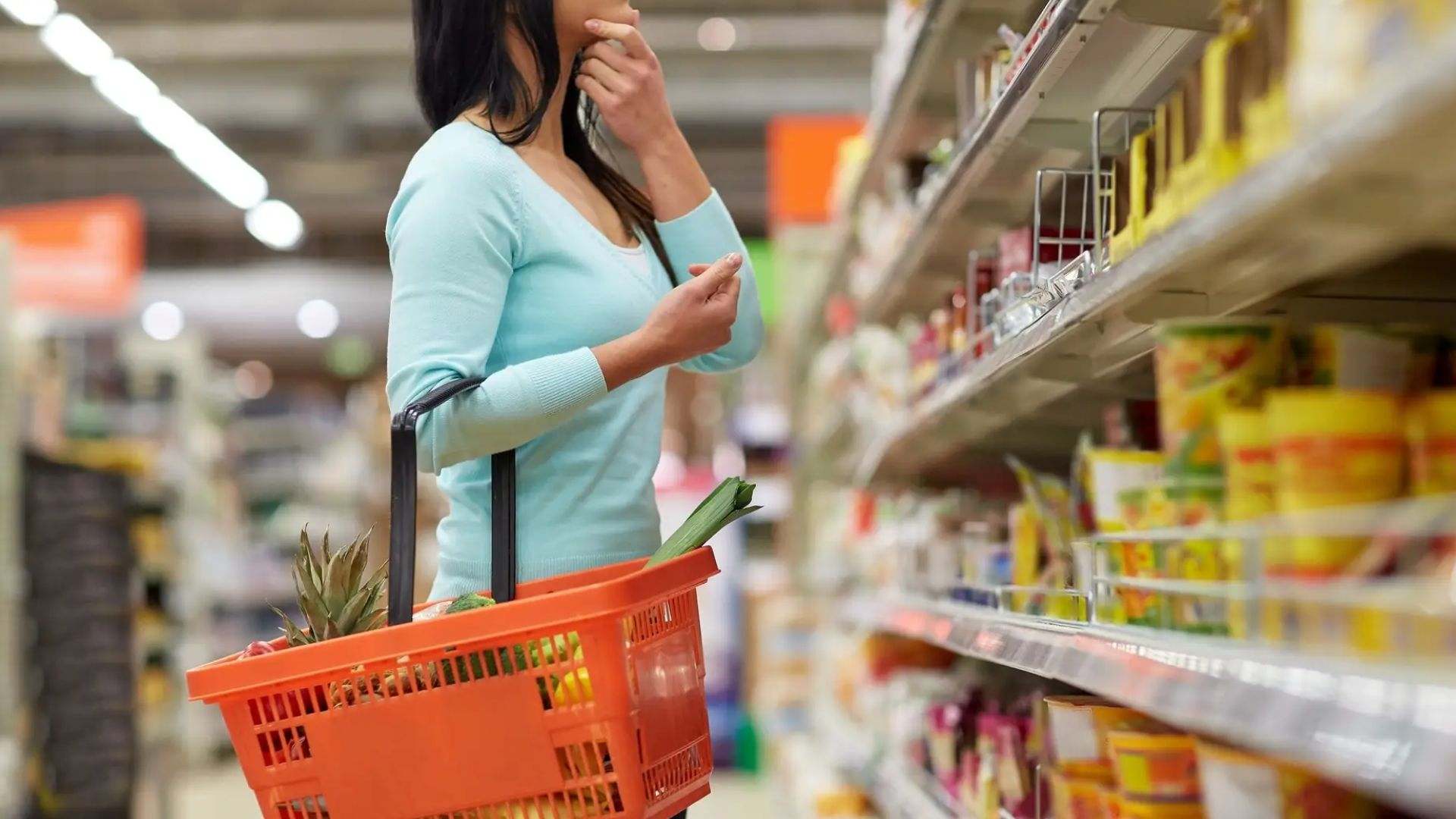 Una mujer está realizando su compra semanal en un supermercado español