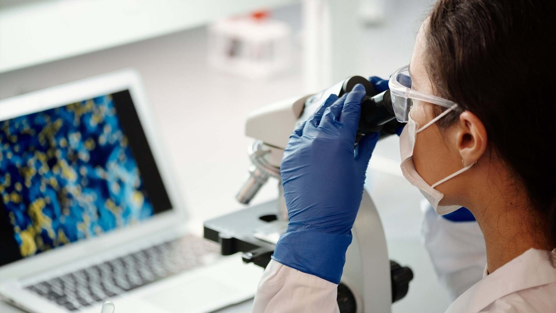 Investigadora utilizando un microscopio en un laboratorio
