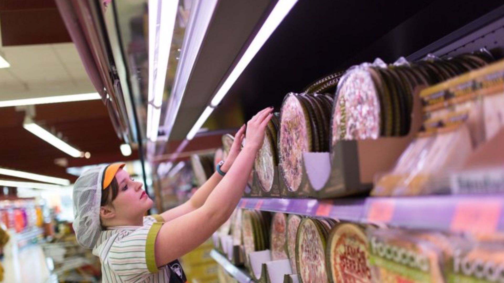 Una trabajadora del Mercadona repone las pizzas