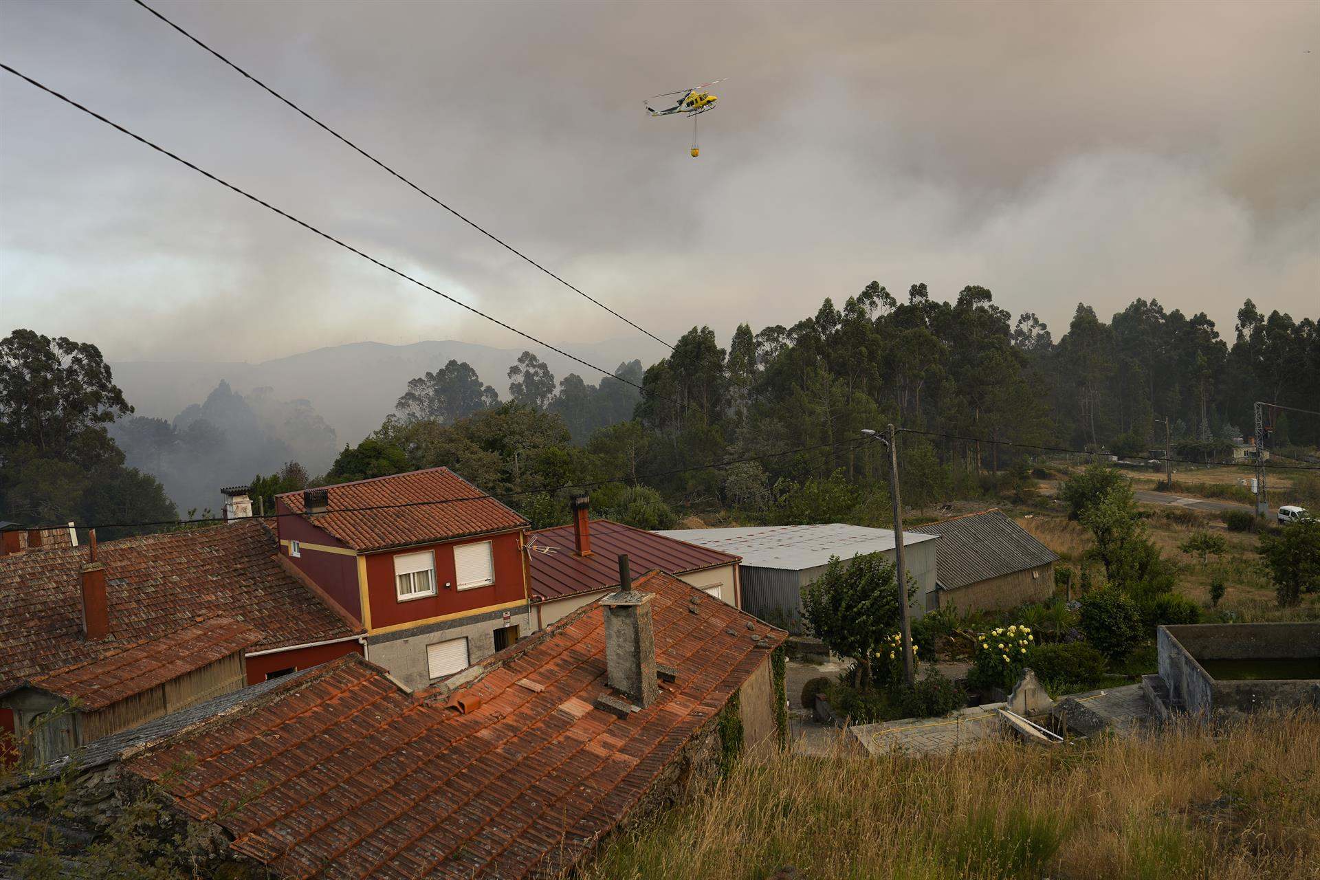 Un helicóptero colabora en las labores de extinción en A Cañiza (Pontevedra).
