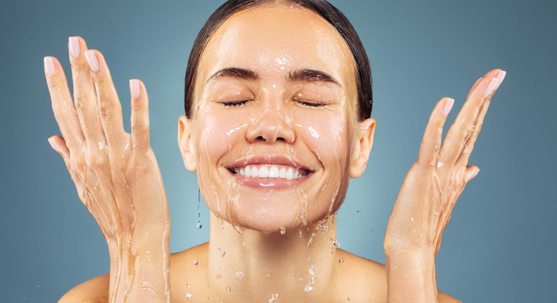 Mujer echándose agua en la cara con los ojos cerrados