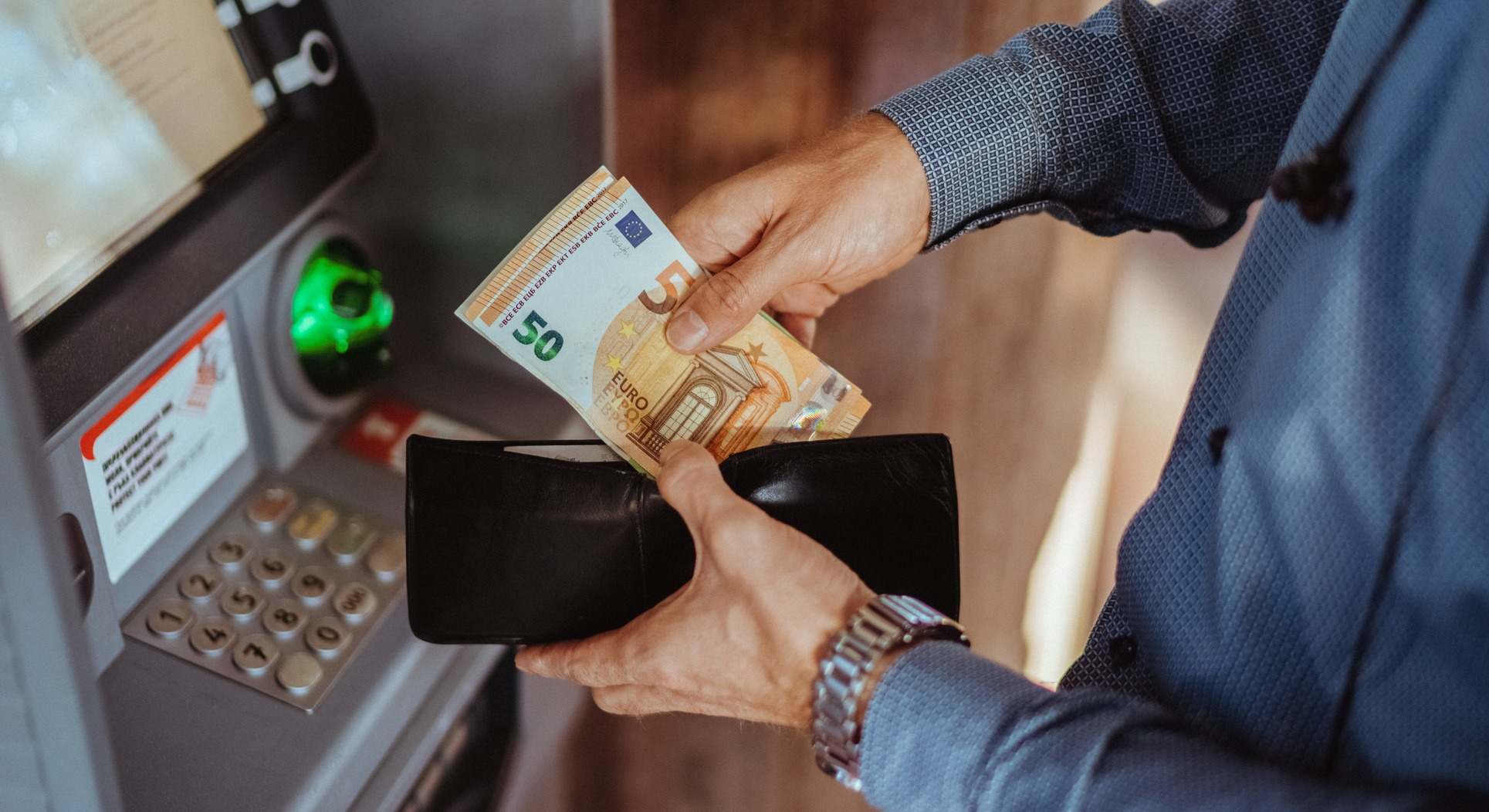 Un hombre sacando dinero de un cajero automático
